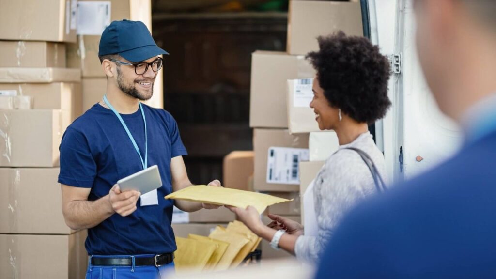 Delivery person handing a package to a customer near a van.