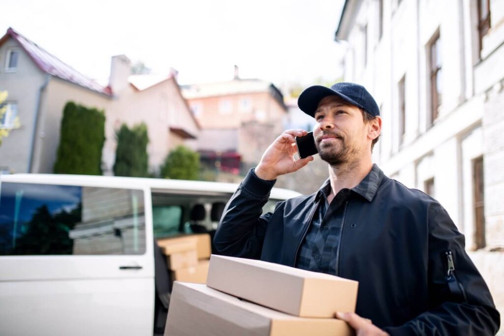 Delivery person on phone coordinating urgent freight shipping